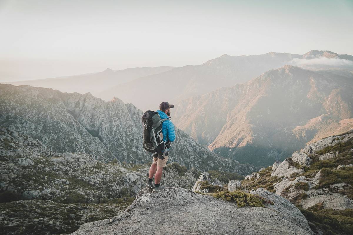 Hiker performing altimeter response time wearable test on mountain trail with reference GPS unit